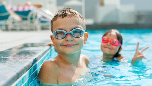 Child wearing googles swimming in pool