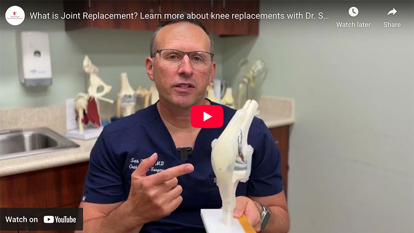 Dr. Seth Korbin is pointing to bone structure of a knee joint