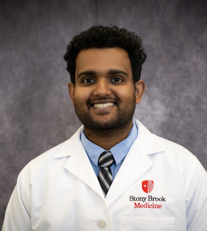 Unni Nair Resident in a Doctor's white coat with a gray background