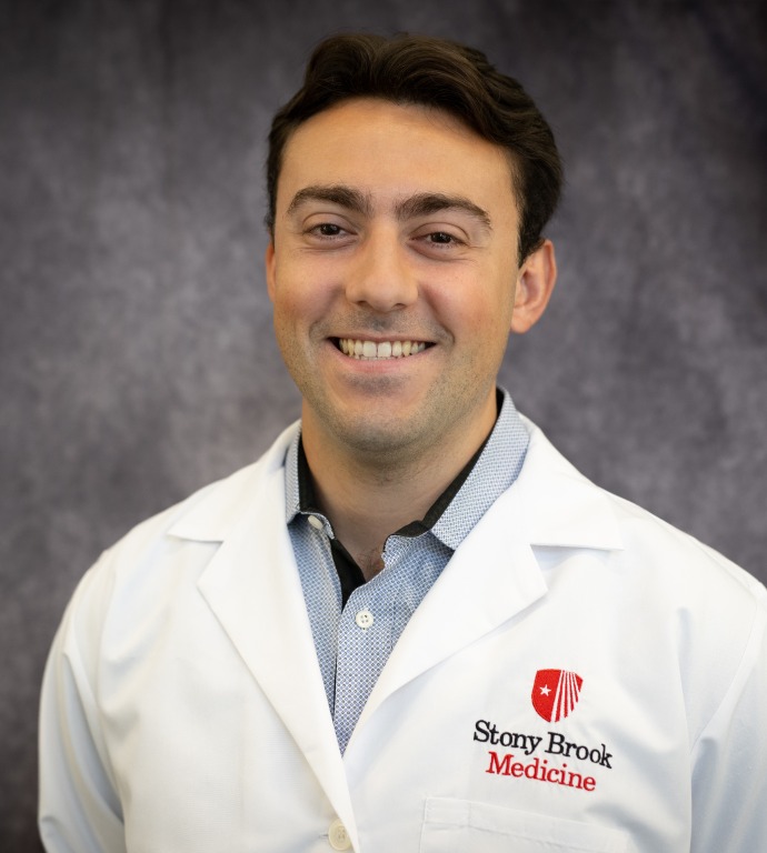 Peter Russo Resident in a Doctor's white coat with a gray background